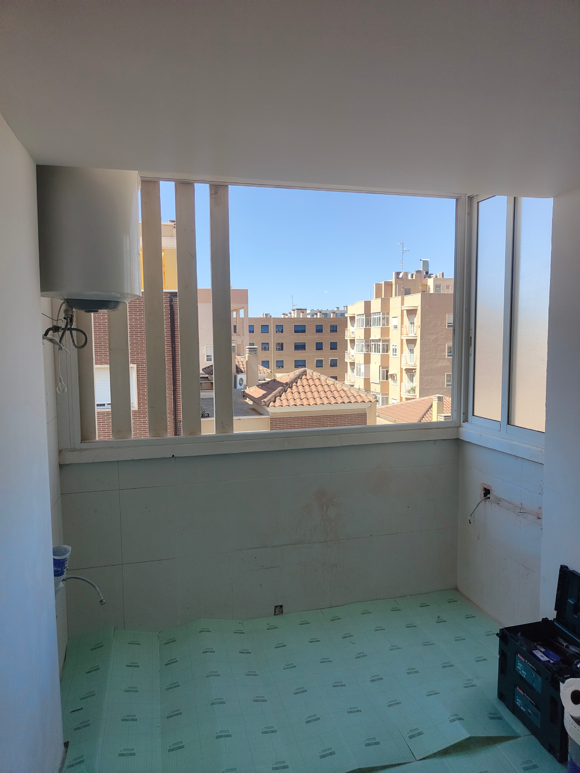 Galeria de un piso todavia abierta al exterior, con vistas a los tejados de la ciudad