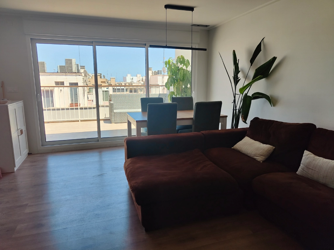 Salon comedor con un ventanal corredero de aluminio que da a la terraza