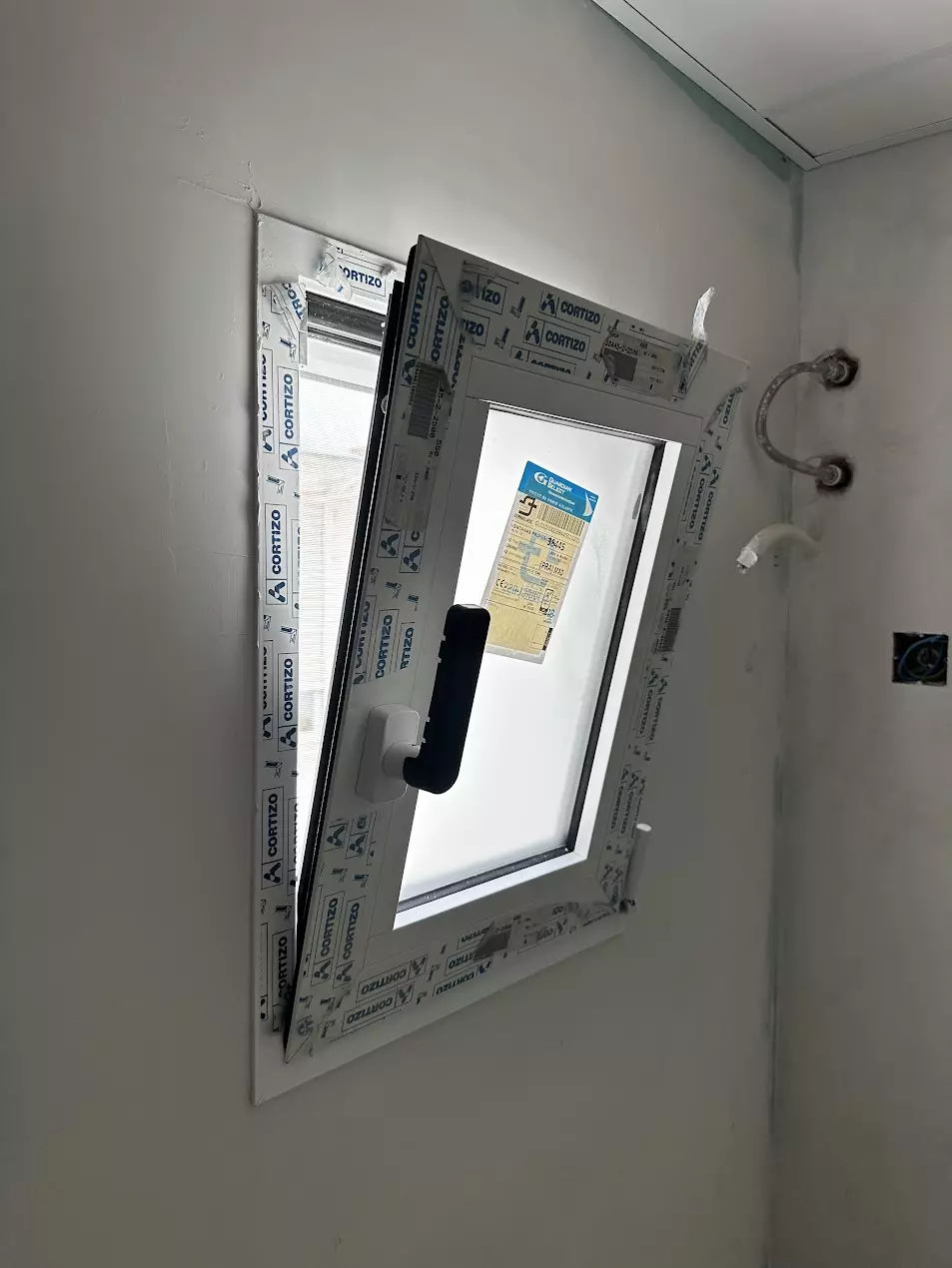 Ventana de PVC con film protector durante los trabajos de sellado tras su instalacion